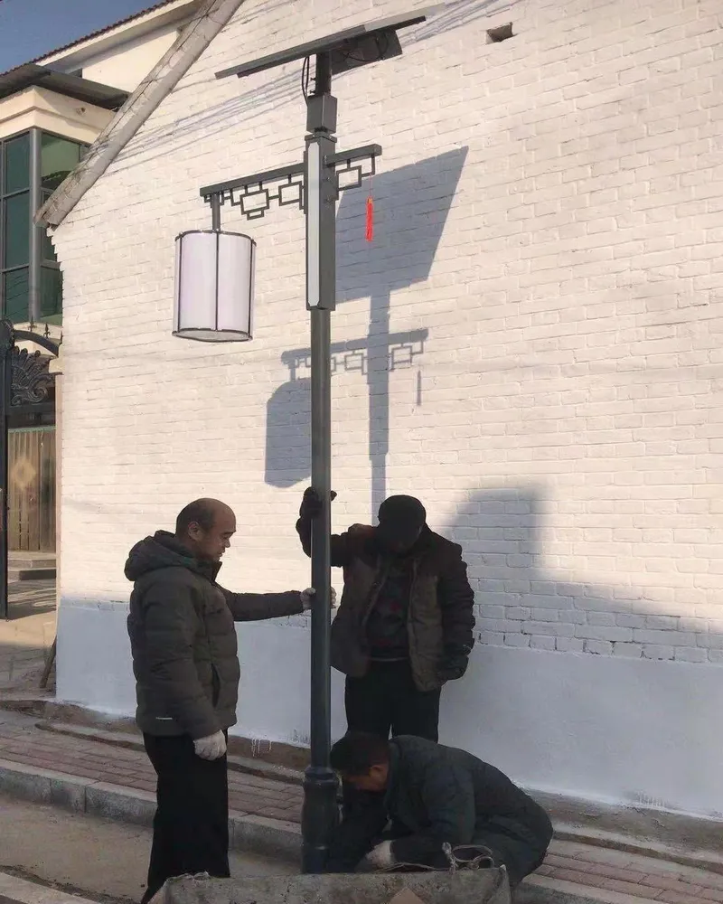 施工人员在白墙旁安装带太阳能板的中式庭院灯