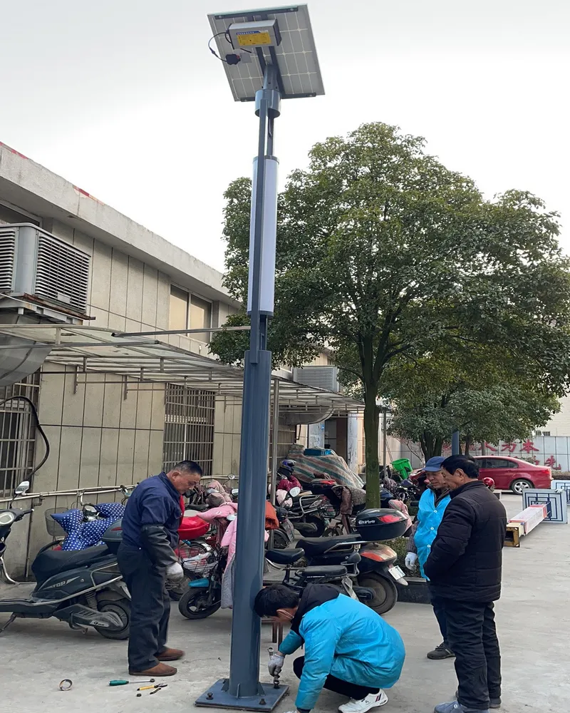 工作人员在建筑旁固定太阳能路灯底座