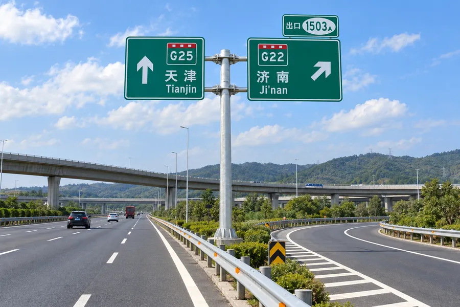 高速公路出口分流处支撑绿色指路牌的双悬臂交通标志杆